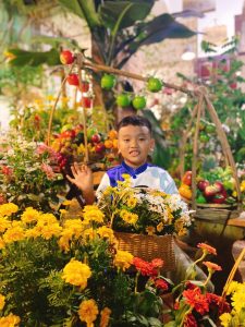 Cậu bé rất vui khi được tham quan không gian sân vườn đầy hoa tại quán chay phương mai