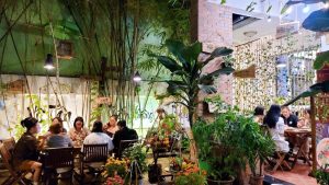 Thực khách dùng bữa trong không gian sân vườn với nhiều cây xanh tại nhà hàng chay phương mai