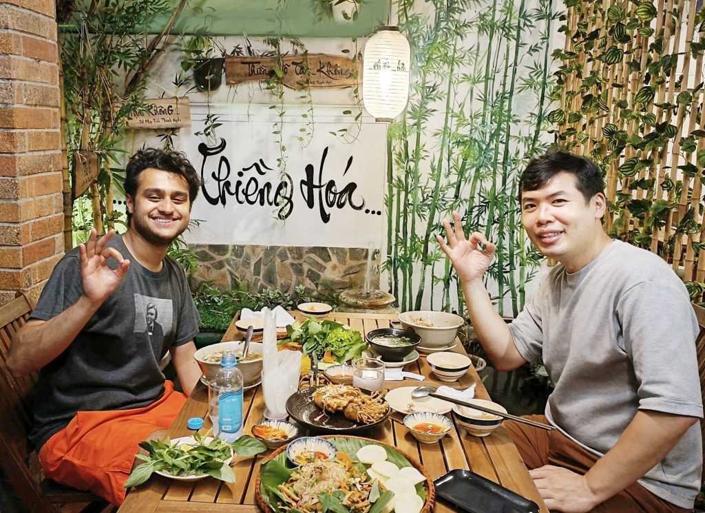 A pair of friends enticing each other to savor delicious dishes at Phuong Mai Vegan Restaurant