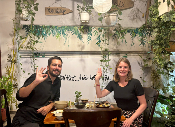 Tourists smiling at healthy plant-based restaurant District 1