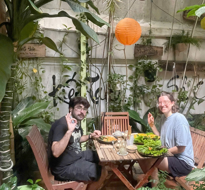 Tourists enjoying plant-based Vietnamese food at a local vegetarian restaurant in Saigon.