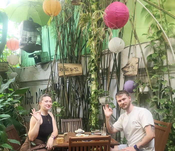 Happy foreign guests dining at a vegetarian restaurant in Ho Chi Minh City.