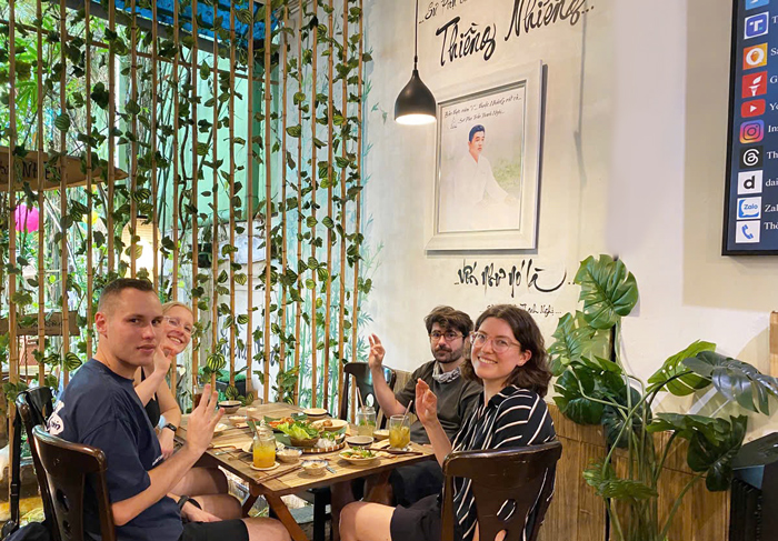 International travelers eating vegetarian Vietnamese food in District 1.