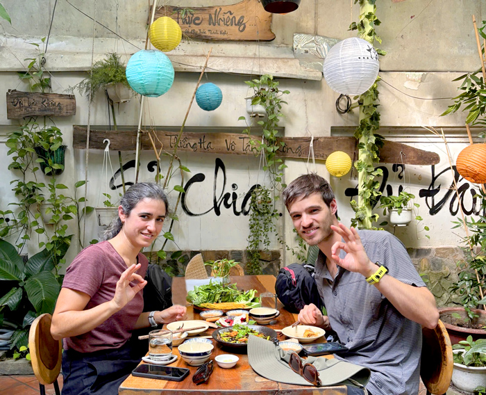 Foreign customers smiling after a vegetarian meal in Saigon.