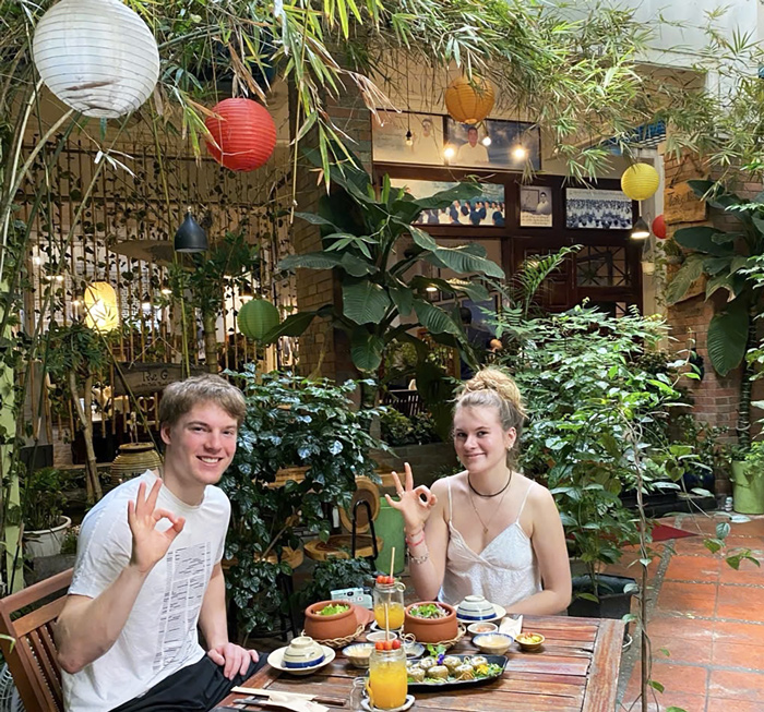 Foreign guests enjoying vegetarian cuisine in a relaxed restaurant setting.