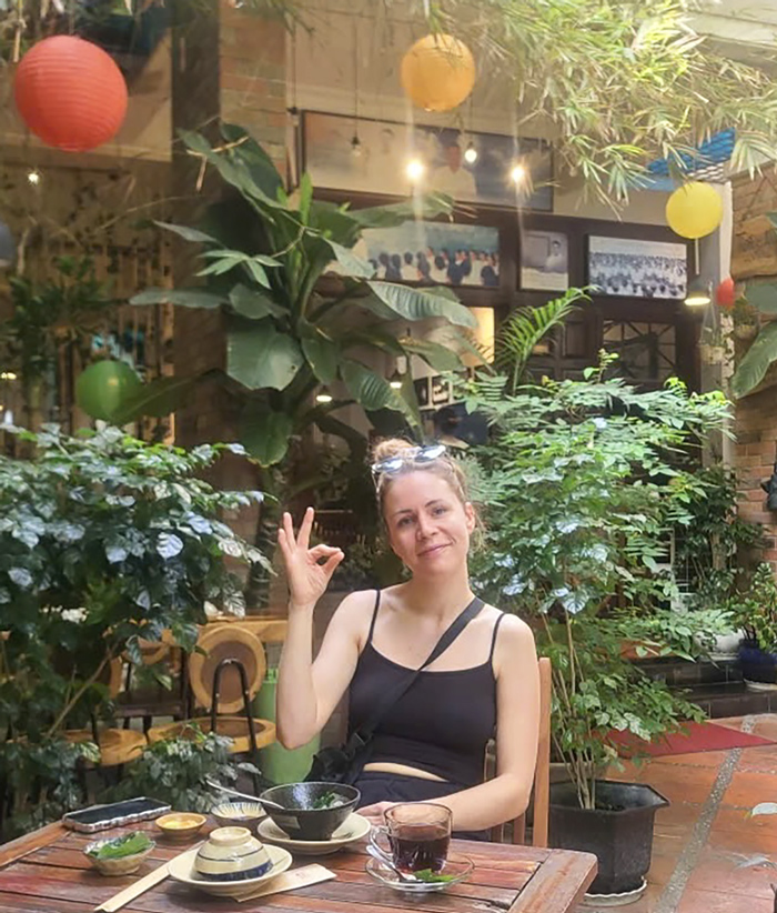 Tourists smiling after a vegetarian dining experience in Saigon.