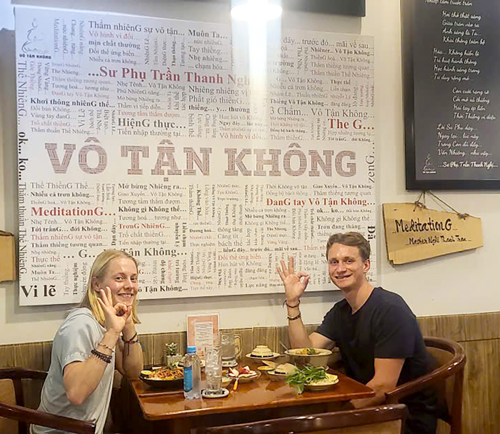 International travelers enjoying vegetarian food in a central Saigon restaurant.