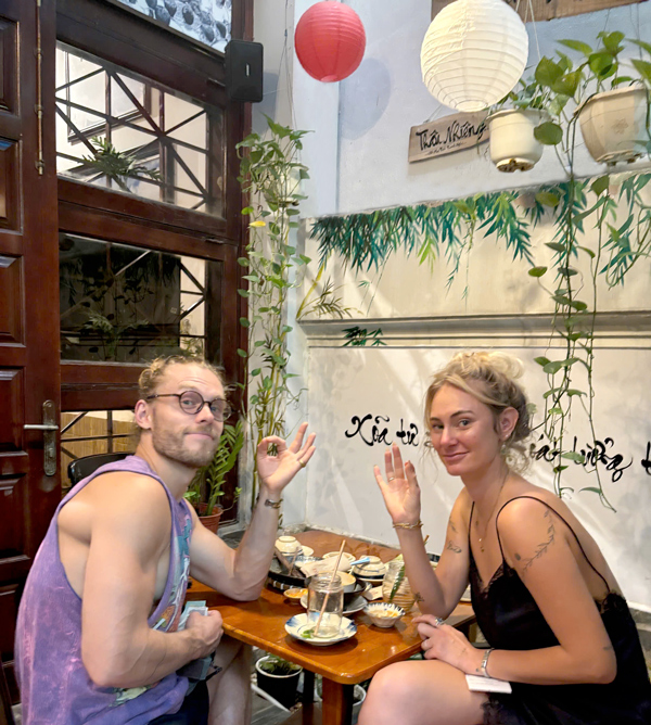 International friends laughing over vegetarian dishes Ho Chi Minh City
