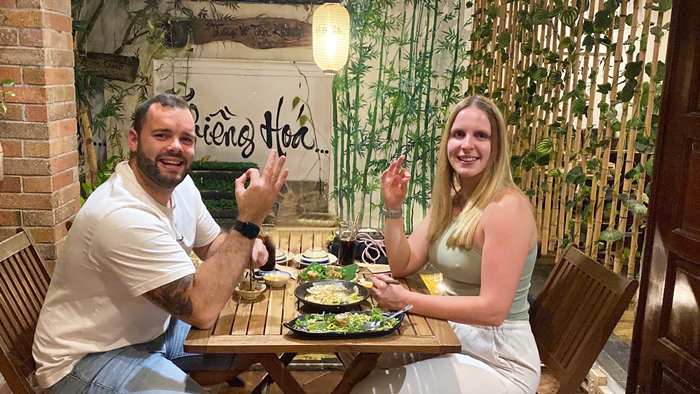 Tourists enjoying plant-based Vietnamese cuisine at a vegetarian restaurant.