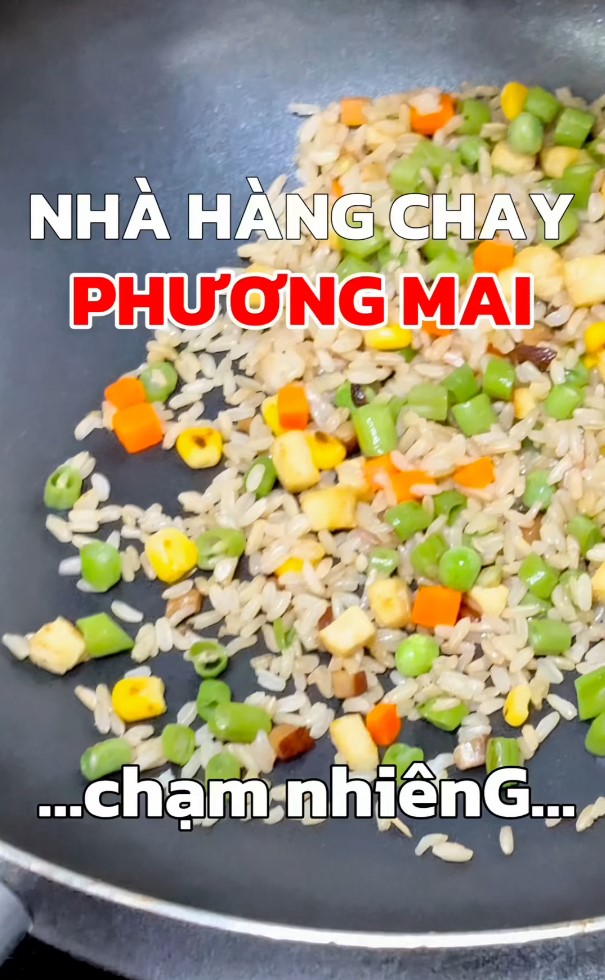 Đầu bếp đang xào nấu món chay tại quán chay Phương Mai, sử dụng rau củ tươi theo mùa, chế biến tối giản để giữ trọn hương vị tự nhiên.